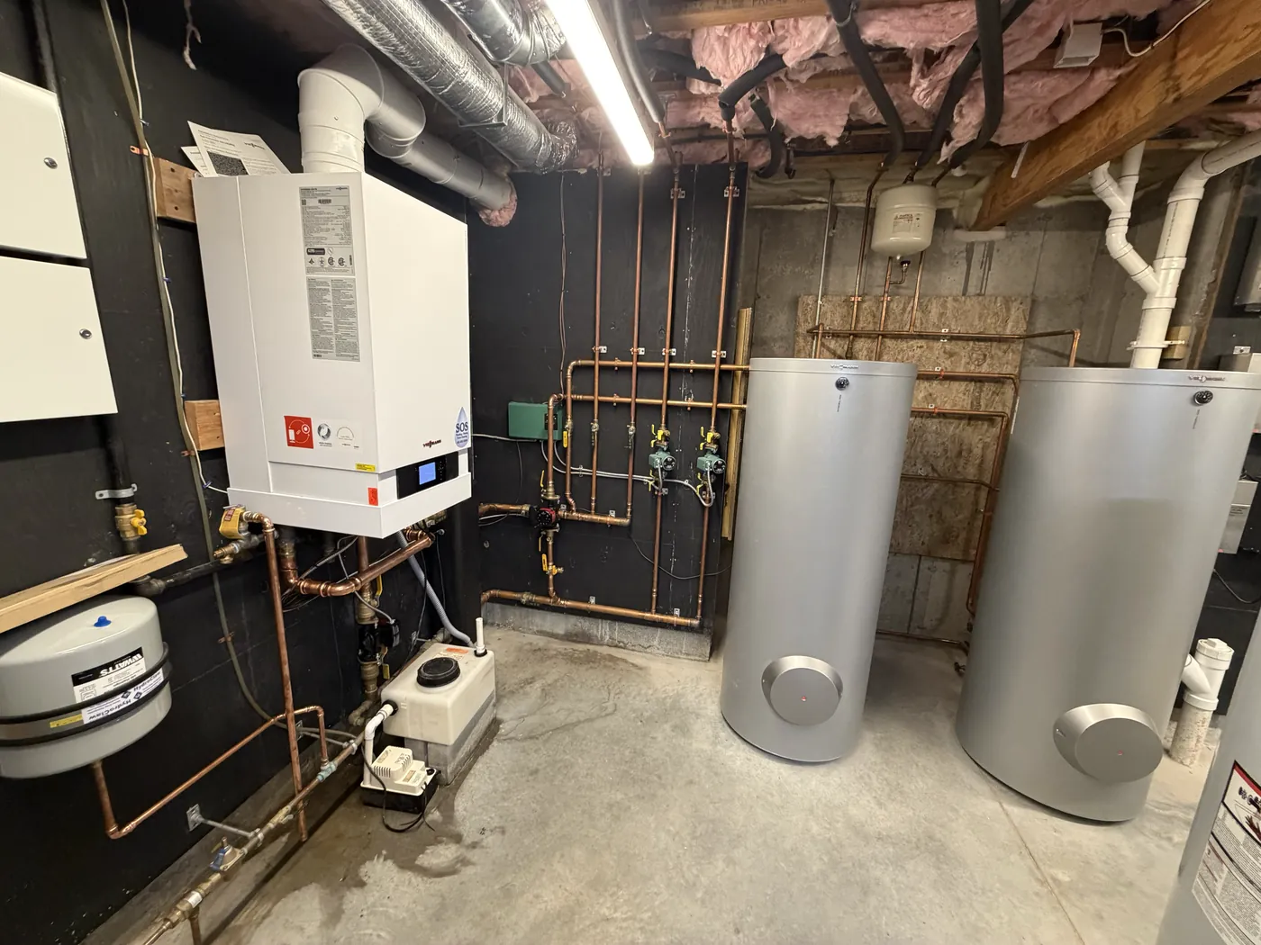 Commercial mechanical room with an SOS-installed condensing boiler and dual hot water storage tanks