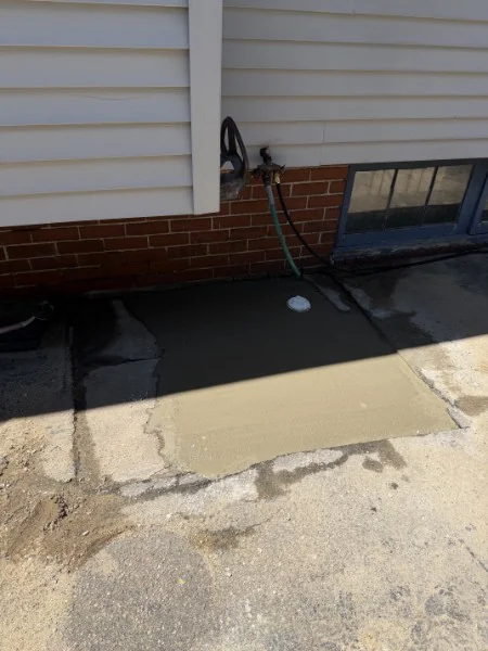 Concrete patched around new PVC plumbing after an SOS repair in Rhode Island