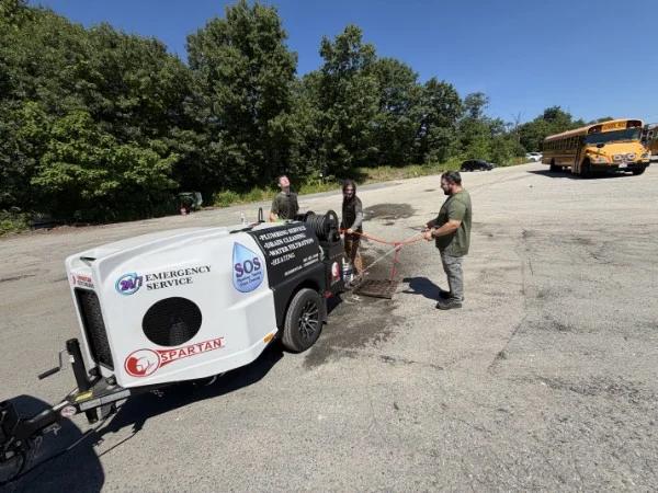 SOS crew servicing a commercial drain line with a trailer-mounted jetter in Rhode Island