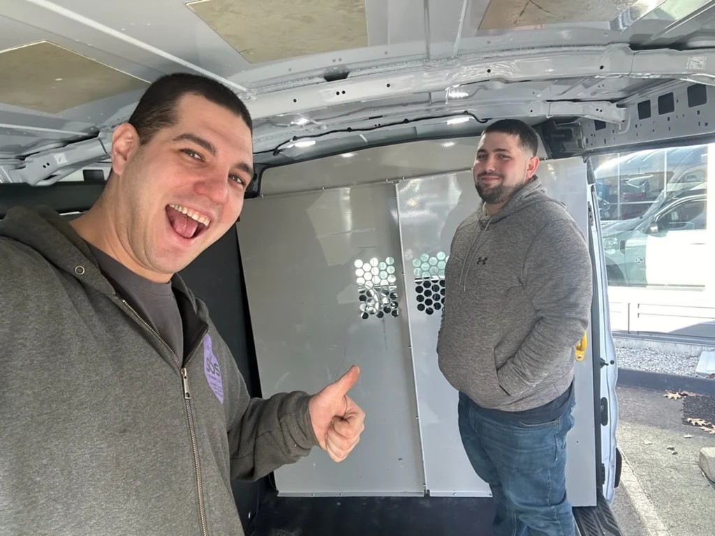 SOS Plumbing & Heating owners inside a stocked service van in Rhode Island