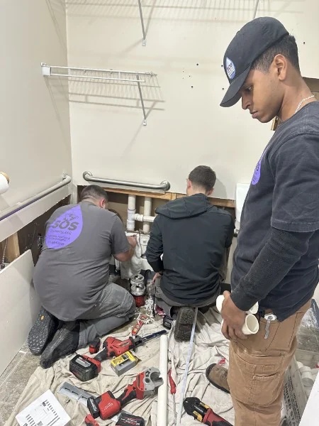 SOS plumber assembling PVC drain piping on a Rhode Island job