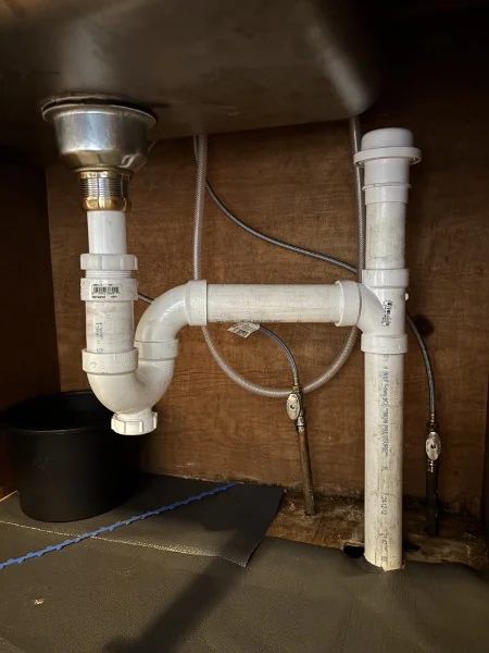 New PVC drain assembly installed under a sink by SOS in Rhode Island