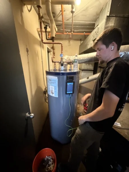 SOS technician servicing a residential water heater in a Rhode Island basement