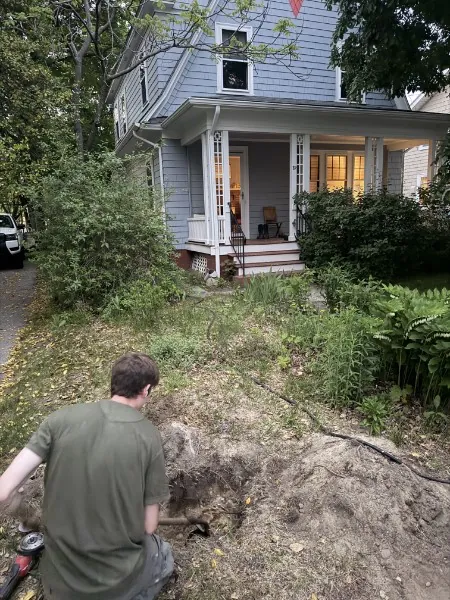 SOS technician excavating in a Rhode Island yard to locate a buried water line